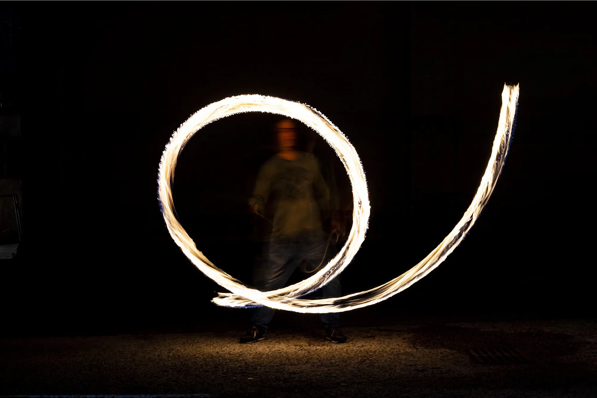Un cèrcol de foc dibuixant una espiral de llum a la foscor