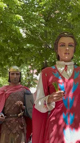 Dos gegants de la Colla Gegantera d’Esparreguera sota els arbres: un soldat romà i una dama amb espigues