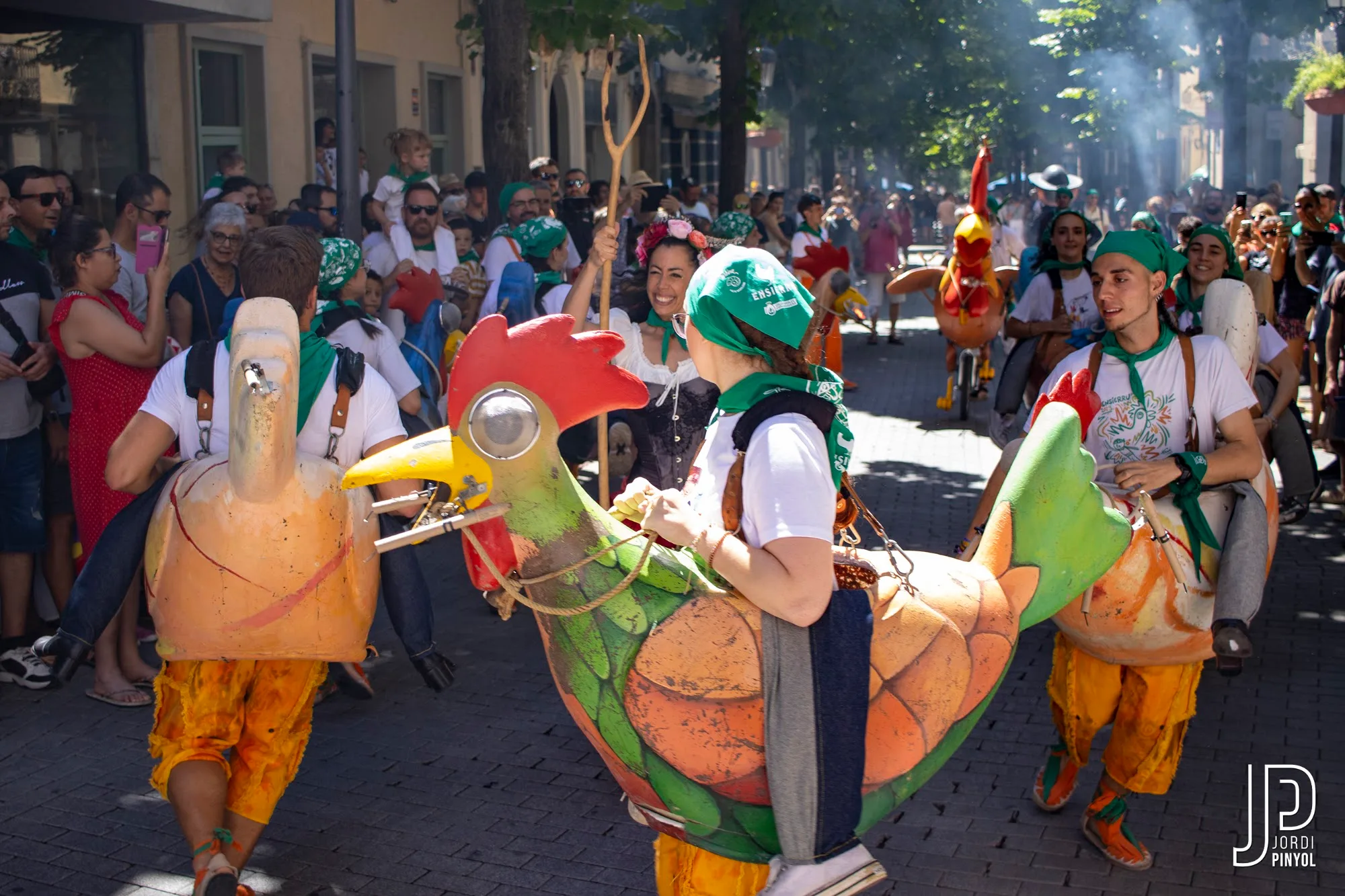 Gallines de colors guiades pels pastors per la plaça