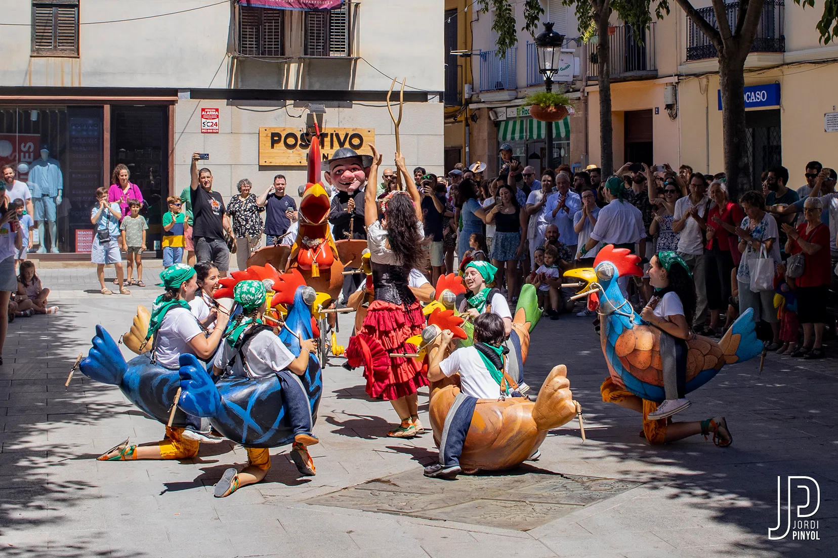 Les gallines reposant a la plaça abans de l’Ensierru, envoltades de gent